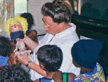Figure 1. Patsy Bjerregaard, paediatric
occupational therapist demonstrating
the effects of smoking on a fetus with
the ‘Smokey Sue Smokes for Two’3 doll